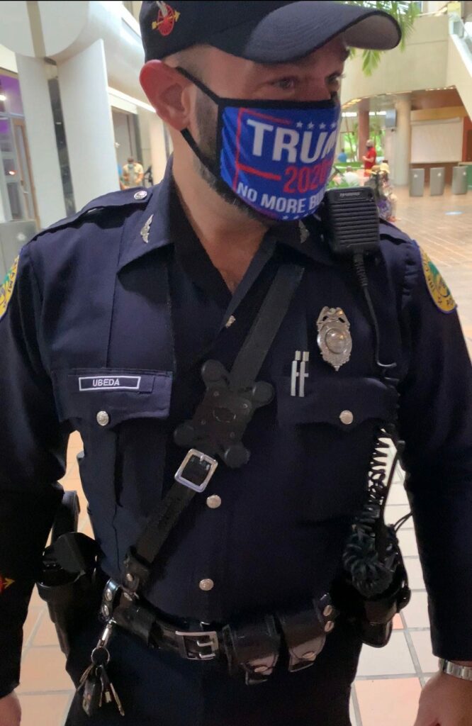 Miami police with Trump mask at polling station